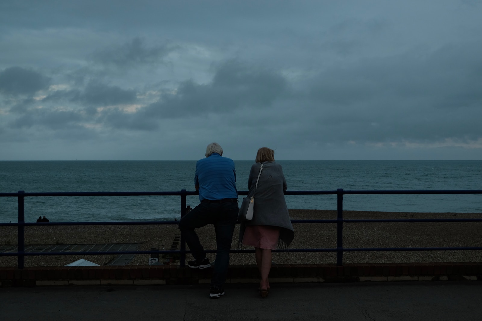 Schattingen couple sitting on bench near sea during daytime